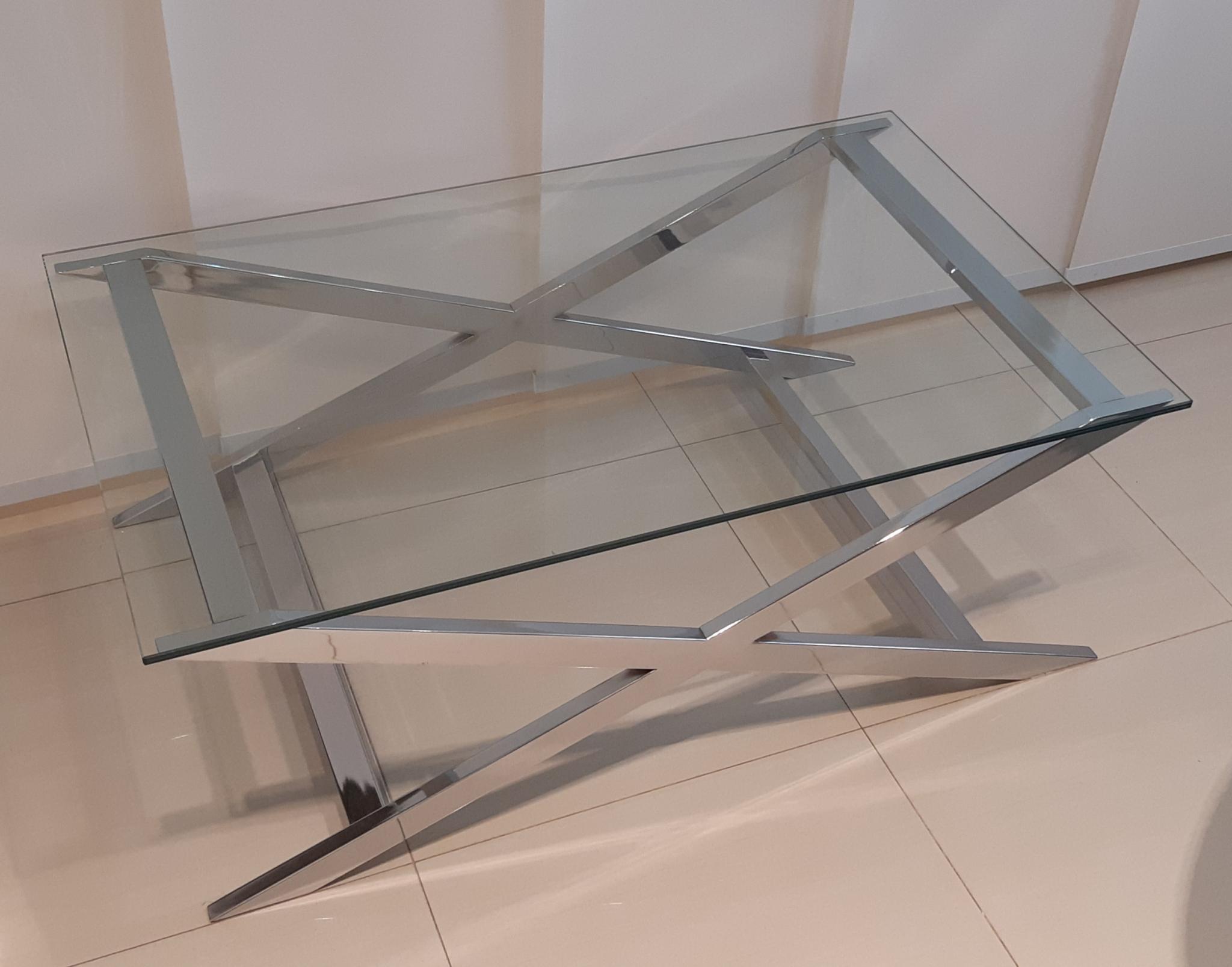 Mesa baja, base tijera cromada y tapa de vidrio. Medidas: 1,00 x 0,62 x 0,38 Mt.