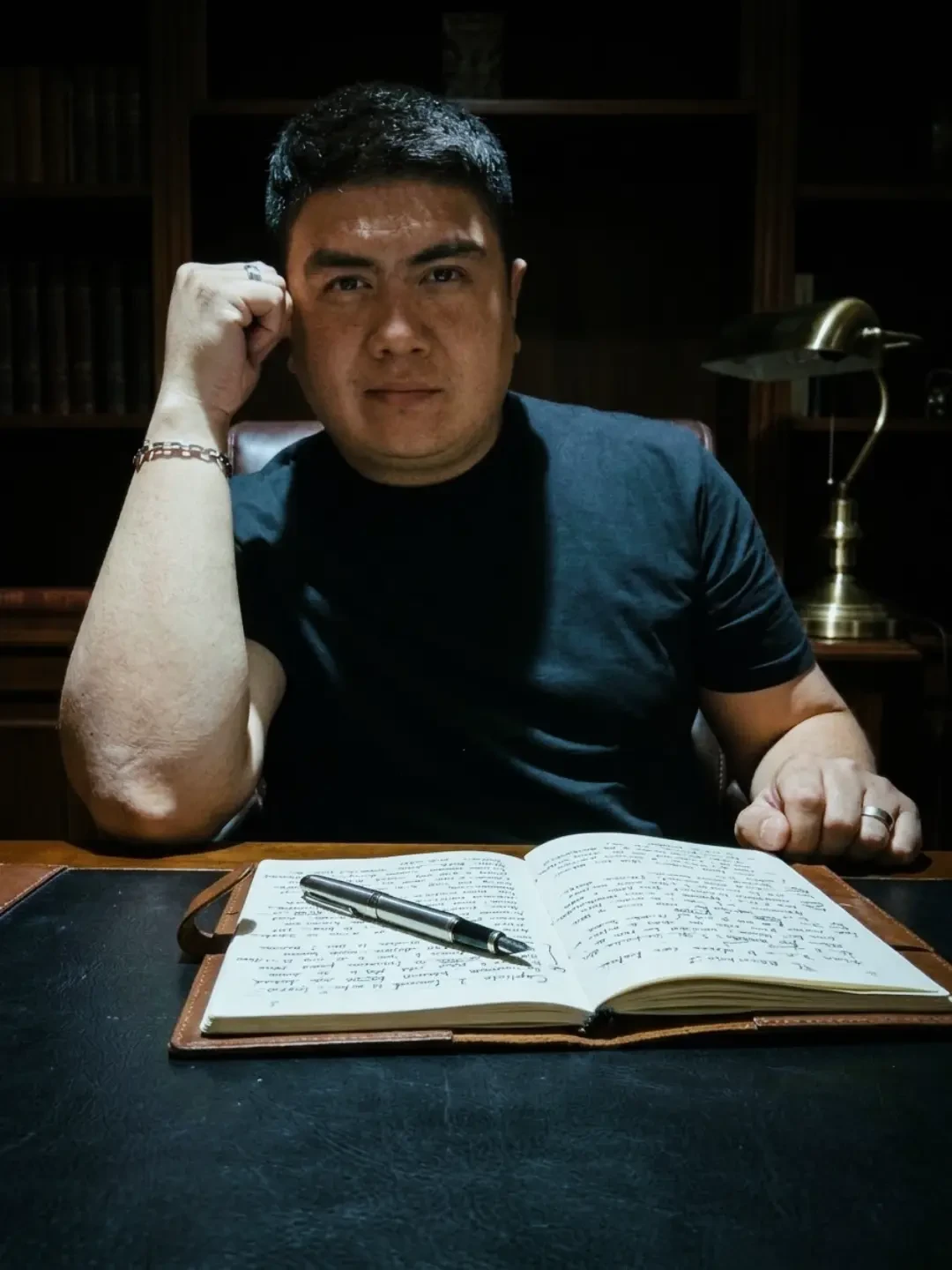 Enrique Caballeros escribiendo en su escritorio, rodeado de libros y café