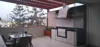 Terraza moderna en departamento con piso de madera y baranda de vidrio en Santiago — Py Construcciones