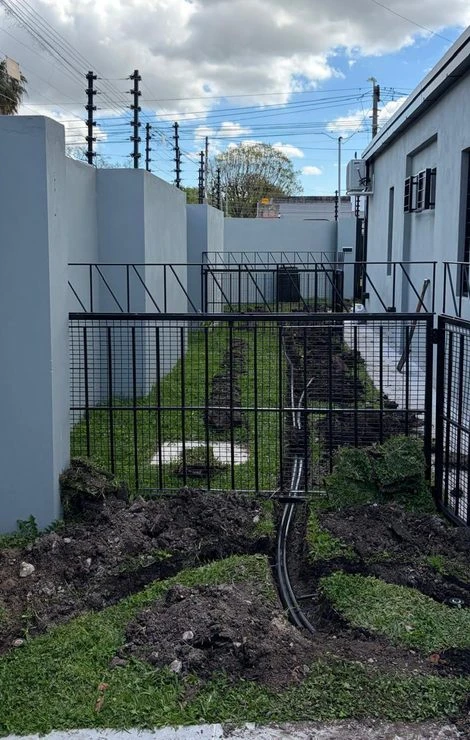 Pasillo lateral con la zanja y las cañerías de riego durante la instalación