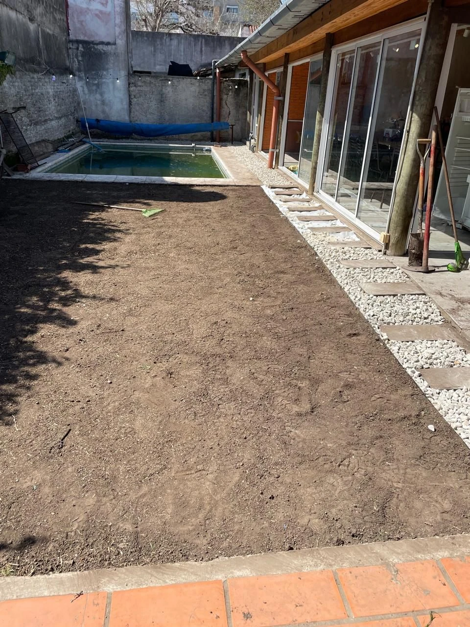 Terreno nivelado junto a una pileta, listo para el césped