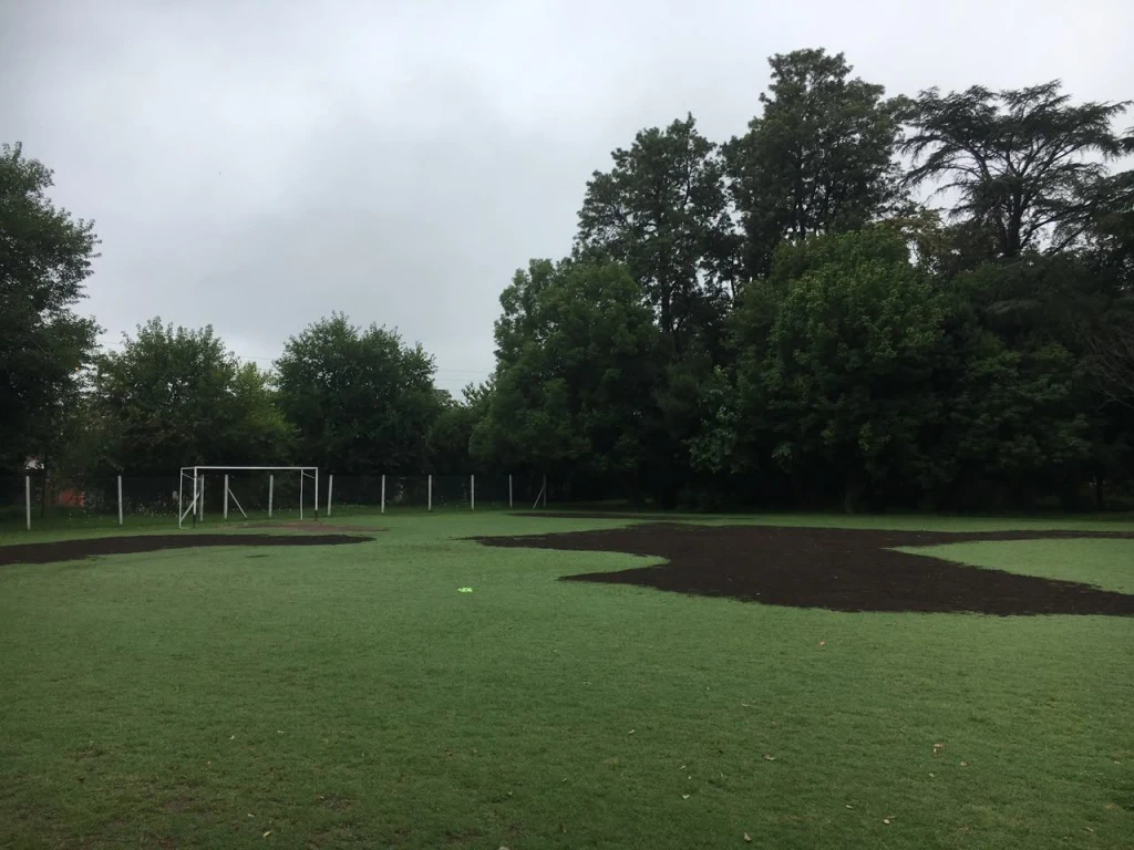Zonas peladas cubiertas con tierra negra para recuperar el césped de la cancha, Castelar