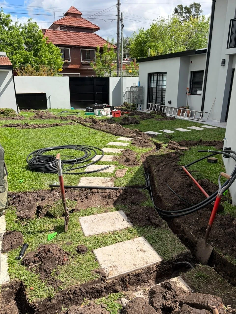 Zanjeo para la instalación de riego automático en un jardín de Zona Oeste