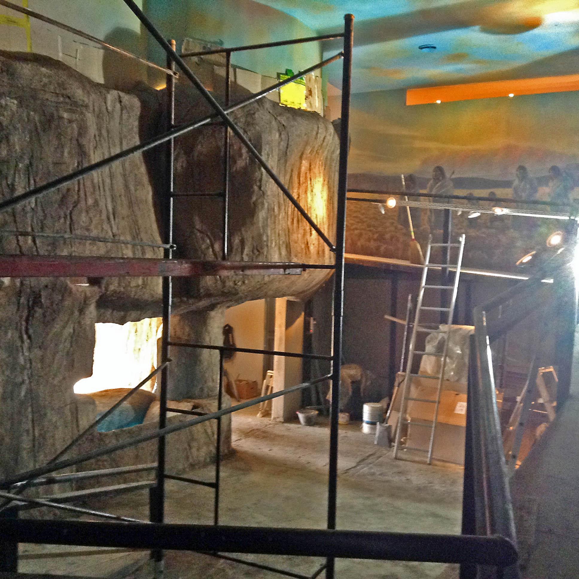Realización de la representación del cañadón del Río, pinturas con roca artificial, ambientación, luminaria de led y fibra óptica sobre mural del cielo patagónico y aborígenes (realizado por Juan Danna).