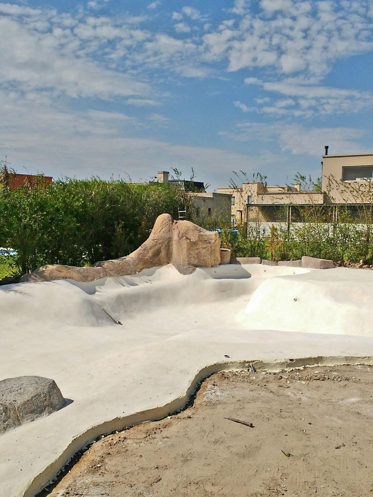 Cascada con rocas sueltas para piscina estilo playa.