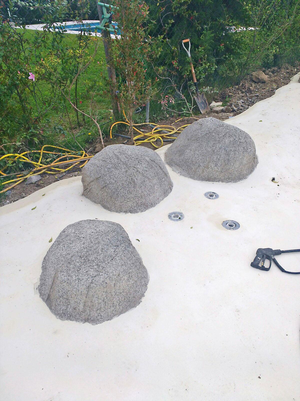 Cascada con rocas sueltas para piscina estilo playa.
