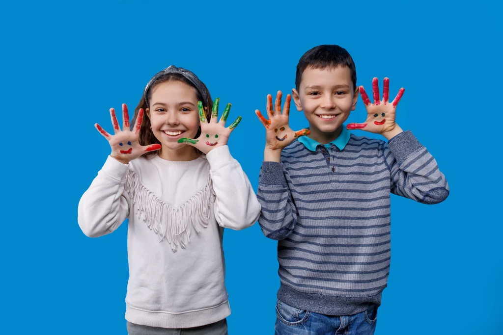 happy-little-boy-girl-with-colored-hands-blue.webp