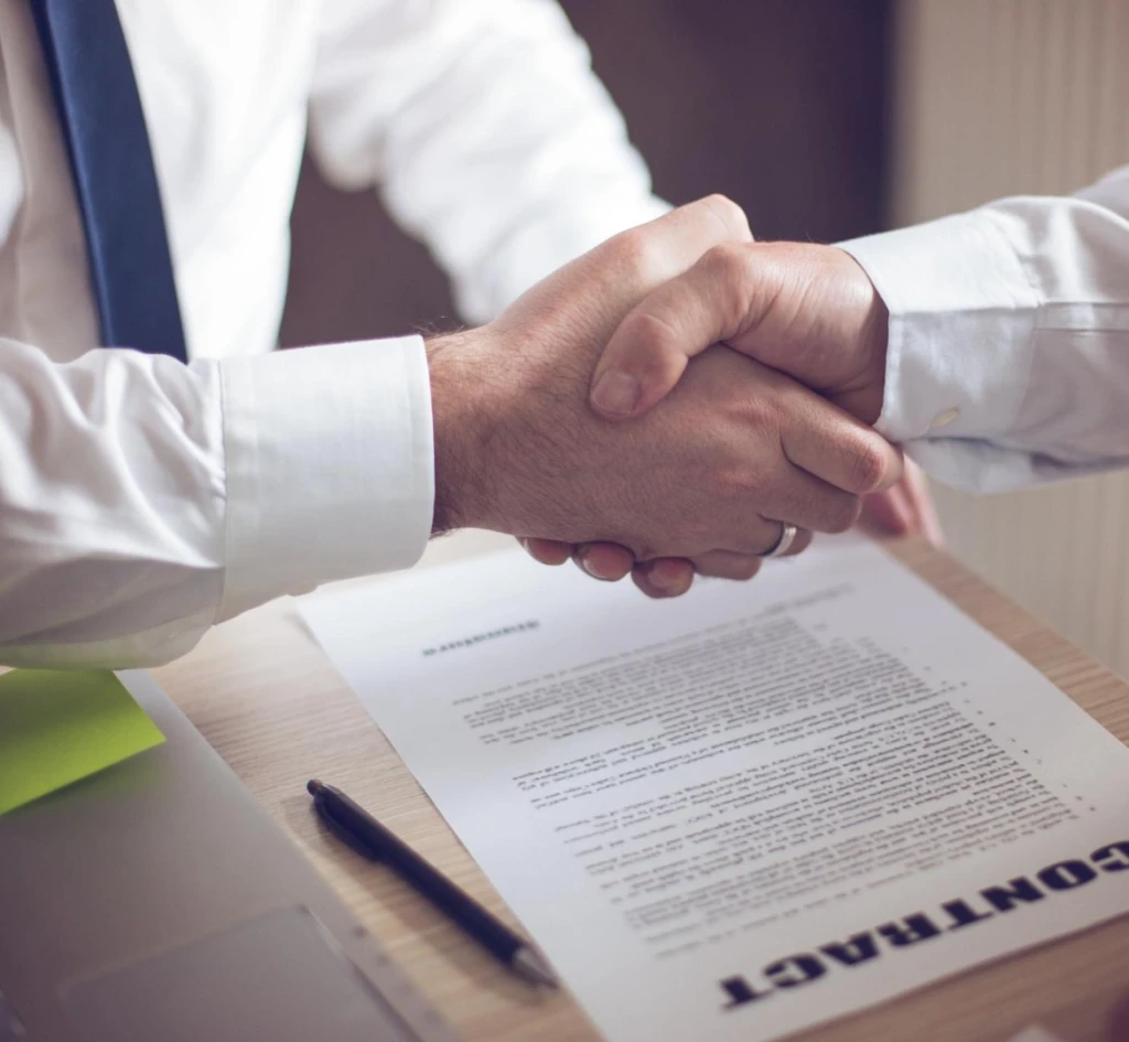 Apretón de manos luego de firmar un un contrato, representando asuntos civiles