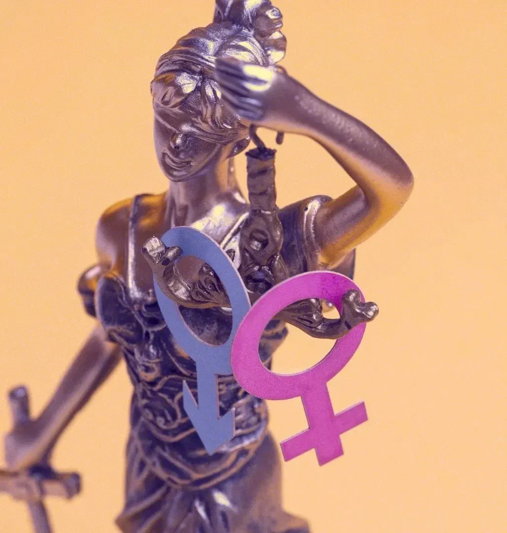 Estatua de la Justicia con símbolos de género, representando la igualdad ante la ley y la protección de derechos.