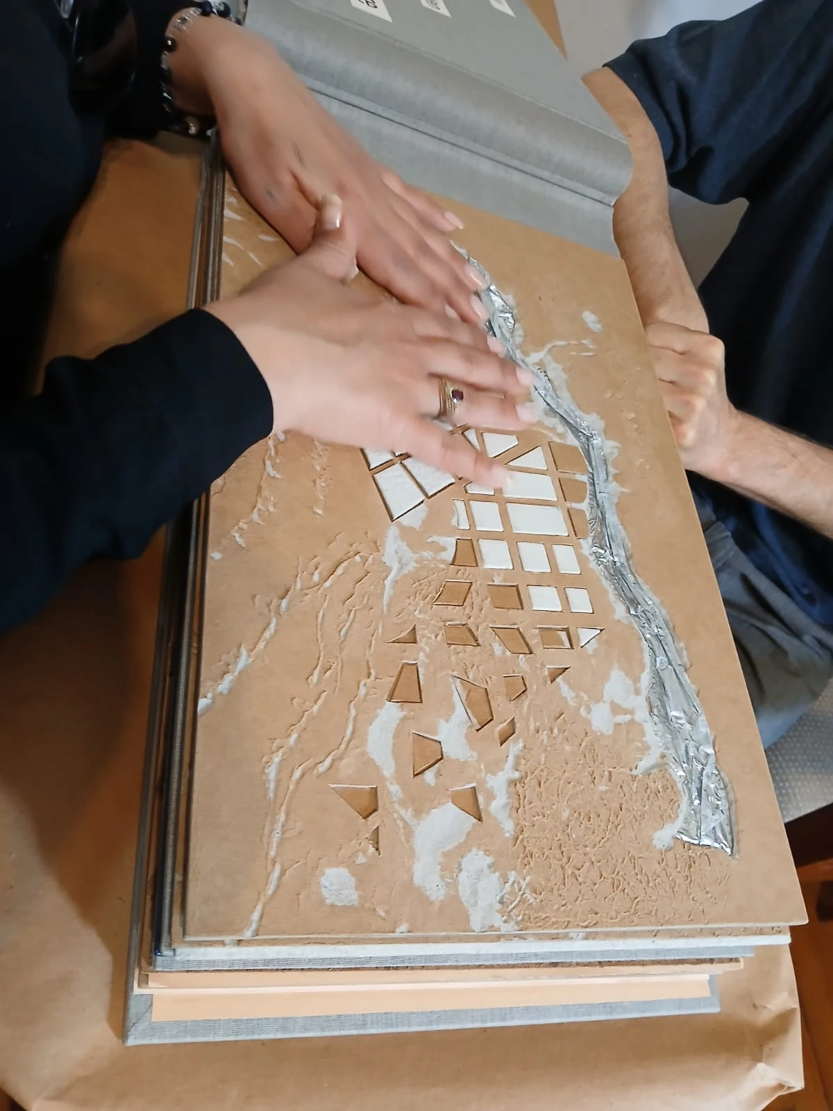 Personas interactuando con libros en braille y tecnología accesible