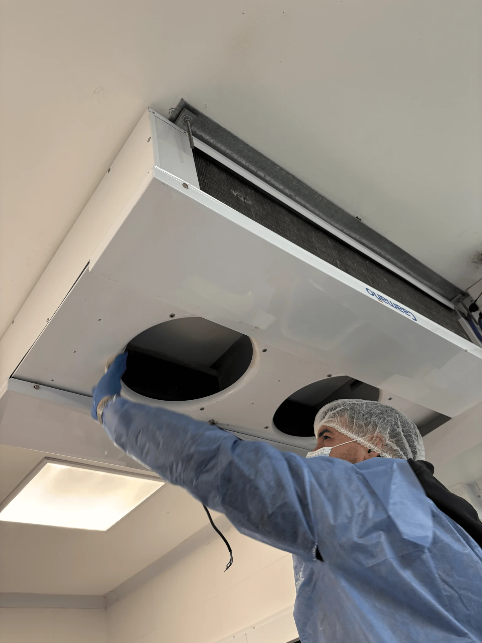 Técnico realizando mantenimiento preventivo en una cámara frigorífica industrial