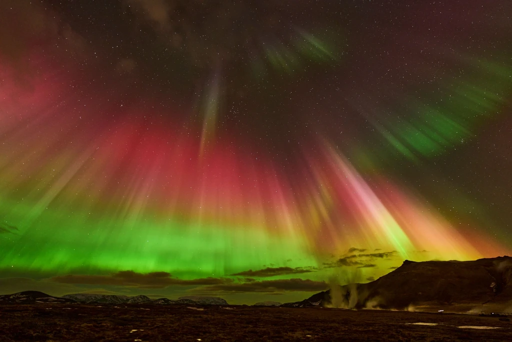 Spectacular multi-tier celestial activity displaying rare red and green Aurora waves.