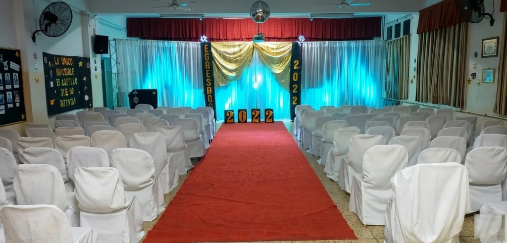 Iluminacion, alfombra roja y sillas vestidas