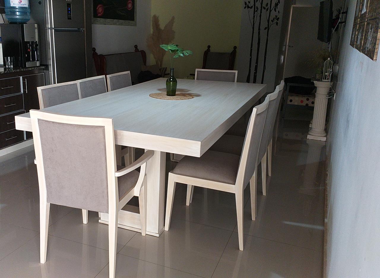 Mesa rectangular con sillas tapizadas y una silla con apoyabrazos en primer plano.