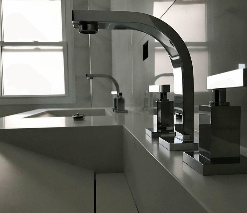 Mesada de baño con bacha integrada y desagote oculto en superficie sólida blanca sin uniones visibles. Material reparable y antibacteriano, alternativa al silestone. Fabricado por Ai-To en Zona Norte.