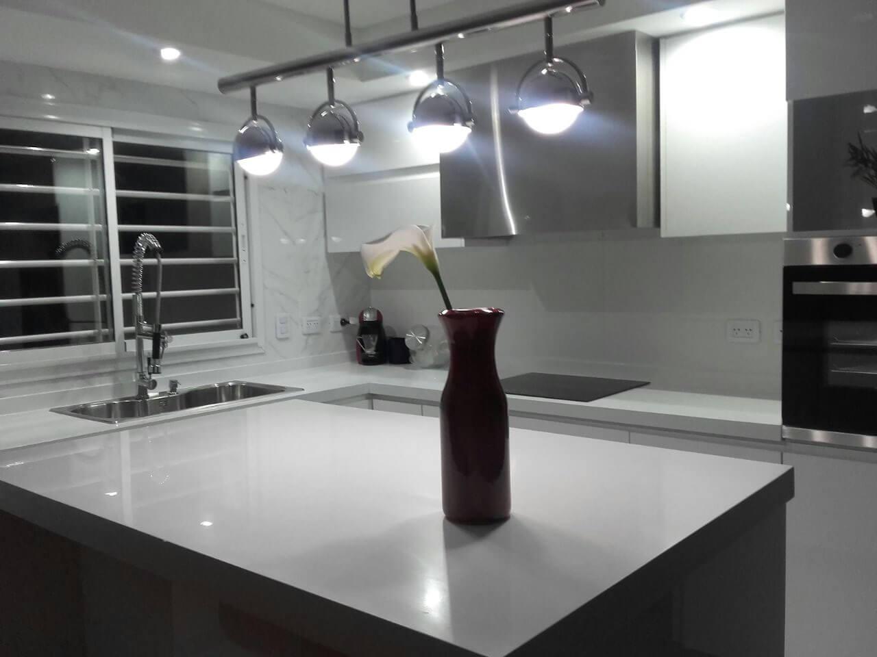 Mesada de cocina en L e Isla en superficie sólida (corian) sin uniones visibles. Material reparable y antibacteriano, alternativa a l silestone, purestone marmol y granito. Fabricado por Ai-To en Zona Sur.