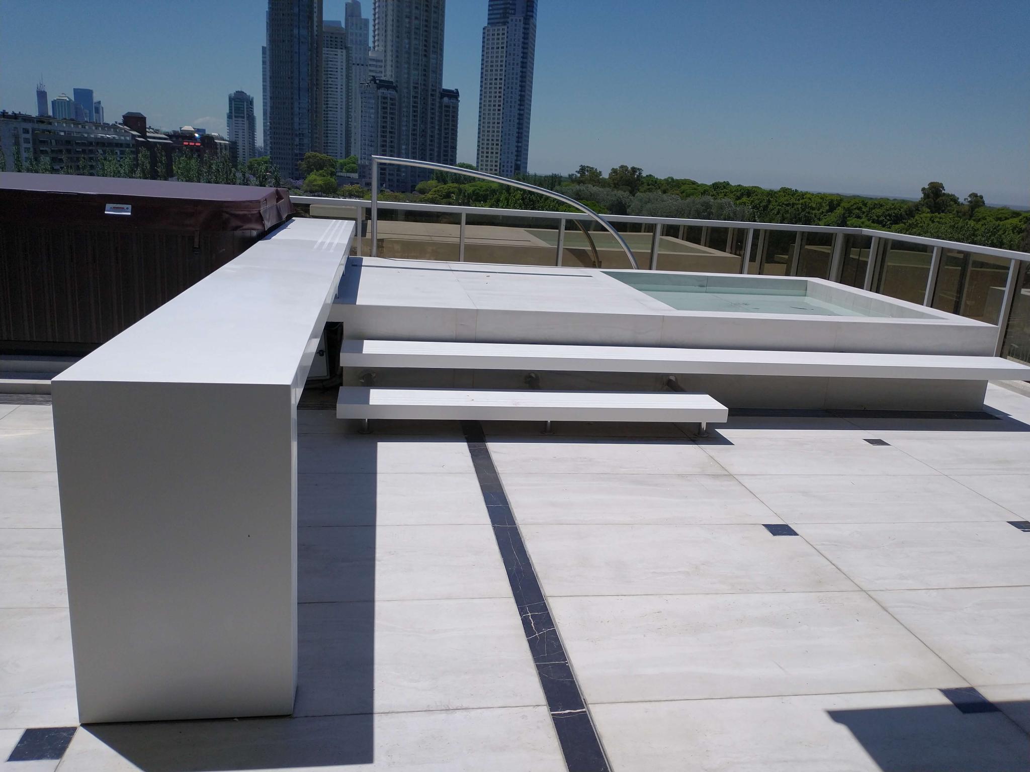 Barra extralarga con pie en cascada y frente ancho en Quarzo alternativa superior silestone fabricado por Aito mobiliario Puerto madero CABA terraza exterior.