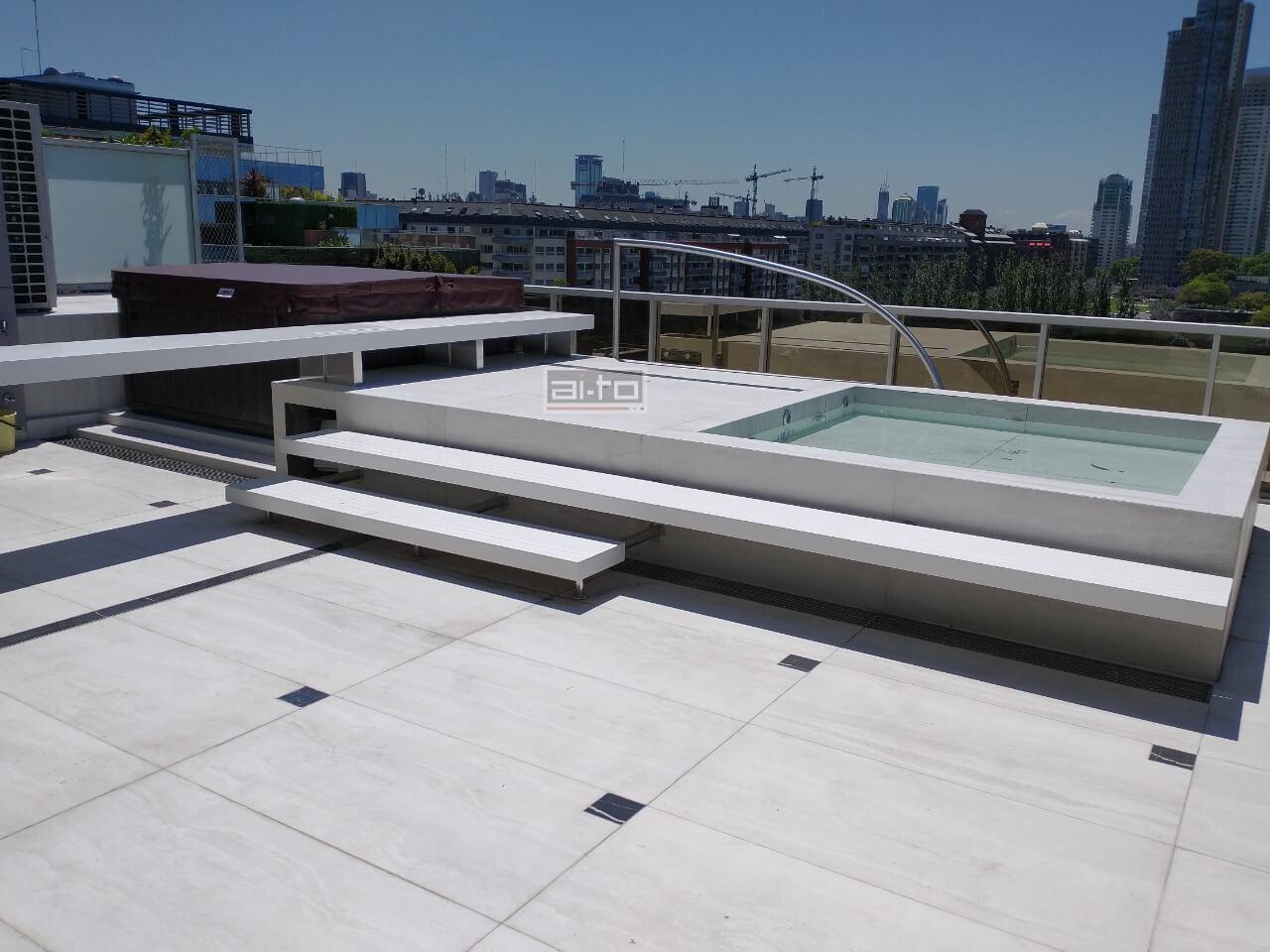 Barra extralarga con pie en cascada y frente ancho en Quarzo alternativa superior silestone fabricado por Aito mobiliario Puerto madero CABA terraza exterior.