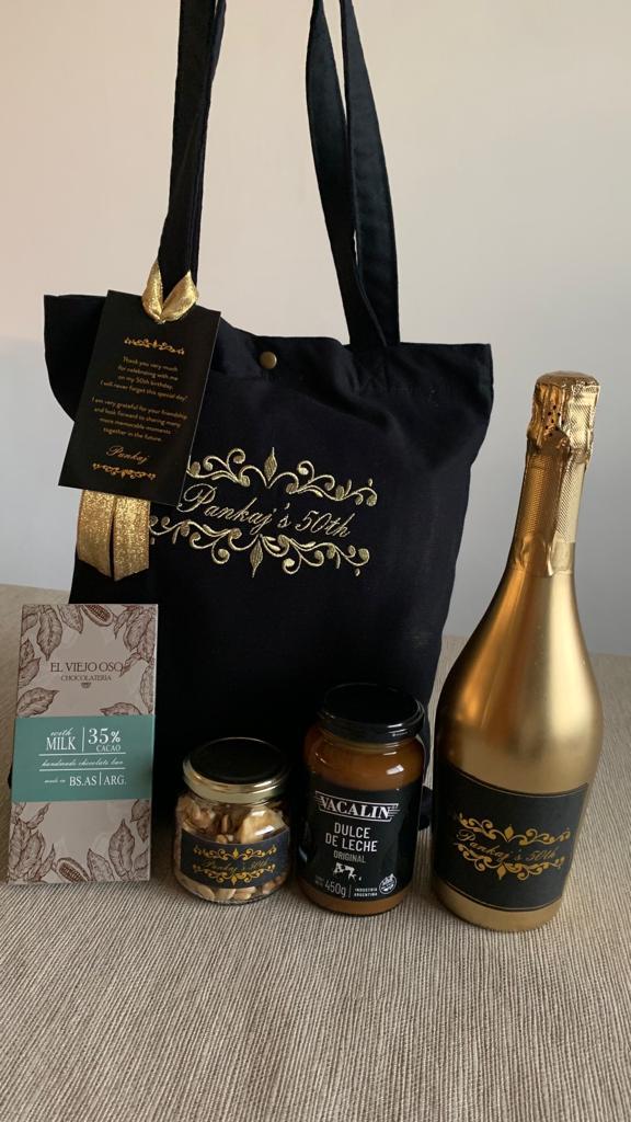 Bolsa de lona negra, con bordado en hilos dorados. Productos regionales de primeras marcas. Etiquetas con hot stamping.